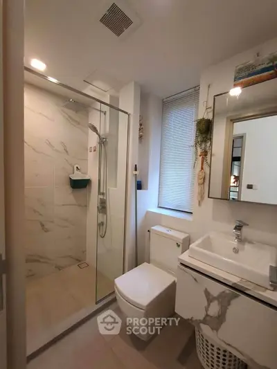 Modern bathroom with glass shower, sleek sink, and stylish decor
