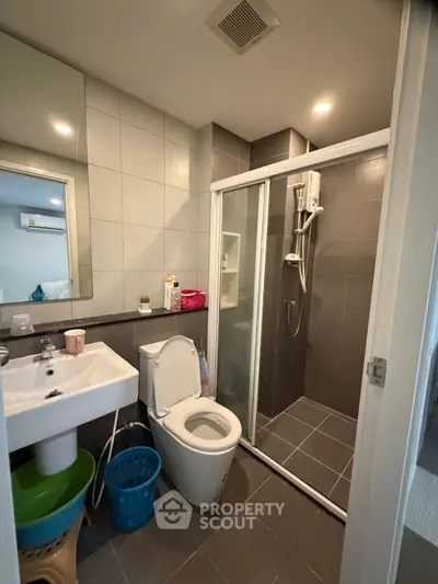 Modern bathroom with shower enclosure and sleek fixtures in a contemporary apartment.