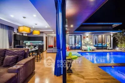 Luxurious open-plan living room with pool view, modern lighting, and elegant decor.