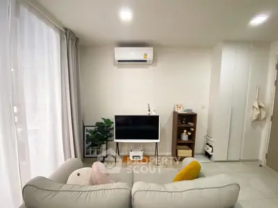 Cozy living room with modern decor and air conditioning, perfect for relaxation.