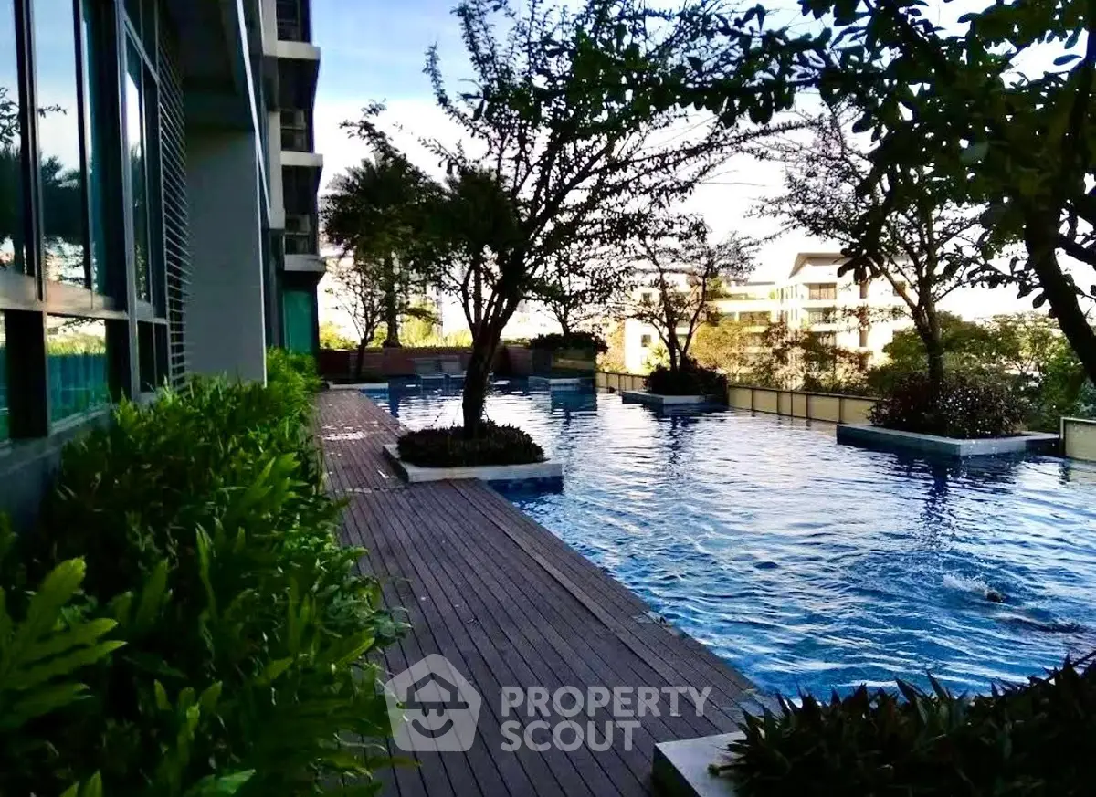 Luxurious residential pool area with lush greenery and modern design, perfect for relaxation and leisure.