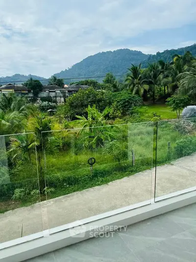 Stunning balcony view with lush greenery and mountain backdrop, perfect for nature lovers.