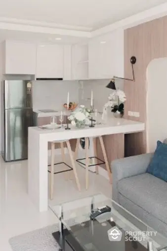 Chic modern studio apartment with a sleek kitchen featuring stainless steel appliances, a cozy dining area, and a comfortable living space, perfect for urban living.