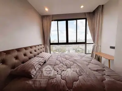 Luxurious bedroom with stunning city view through large windows, featuring elegant decor and cozy bedding.