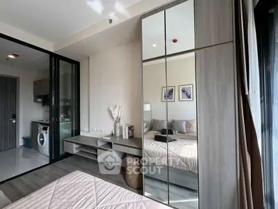 Modern bedroom with mirrored wardrobe and compact laundry area
