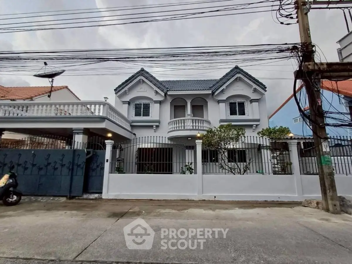 Charming two-story house with classic architecture and gated entrance, perfect for family living.