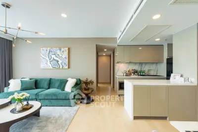 Modern open-plan living room and kitchen with stylish decor and green sofa.