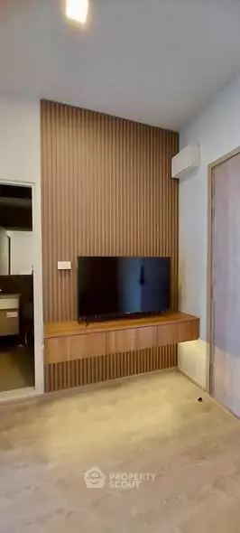 Modern living room with sleek TV setup and wooden panel accent wall