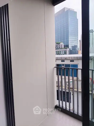 Modern apartment balcony with cityscape view and sleek railing design.