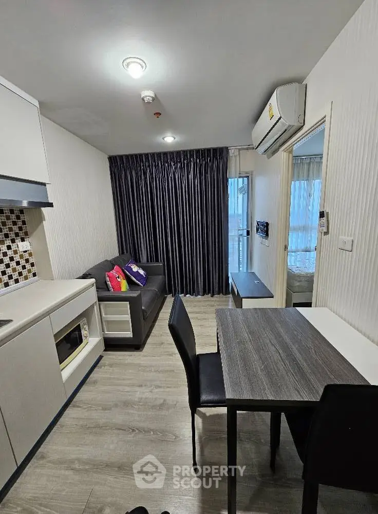 Modern living room with sleek furniture and open kitchen layout in a stylish apartment.