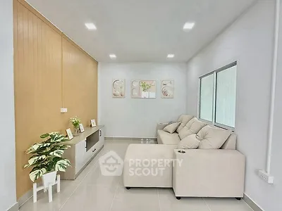 Modern living room with beige sectional sofa and stylish decor in a bright, minimalist space.