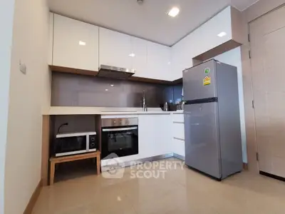 Modern kitchen with sleek white cabinets, stainless steel appliances, and spacious layout.