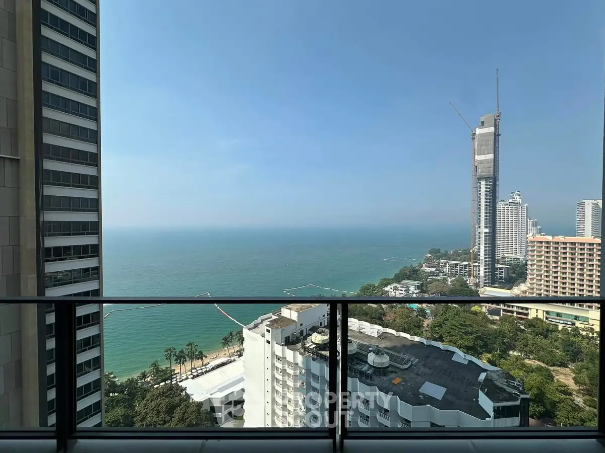 Stunning ocean view from high-rise balcony overlooking cityscape and coastline.