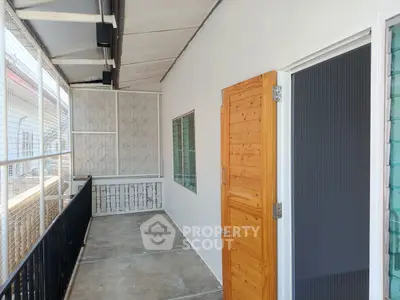 Spacious balcony with modern design and wooden door, perfect for relaxation and outdoor enjoyment.