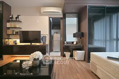 Modern living room with sleek design and integrated kitchen area, featuring stylish decor and natural lighting.