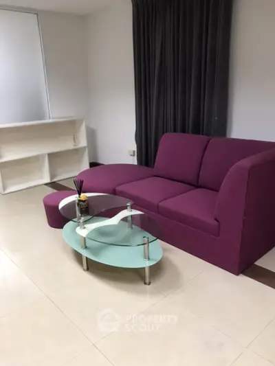 Modern living room with purple sofa and glass coffee table