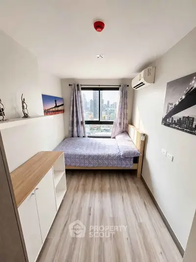 Cozy bedroom with city view, featuring modern decor and ample natural light, perfect for urban living.