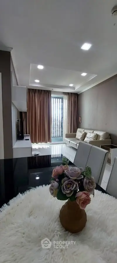 Modern living room with elegant decor and large windows offering natural light.