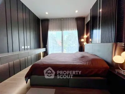 Luxurious modern bedroom with sleek design and large window offering natural light.