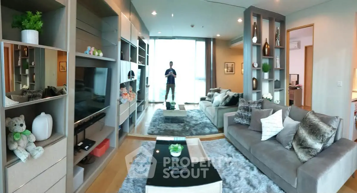 Luxurious modern living room with plush sofas, stylish decor, and large windows offering natural light.
