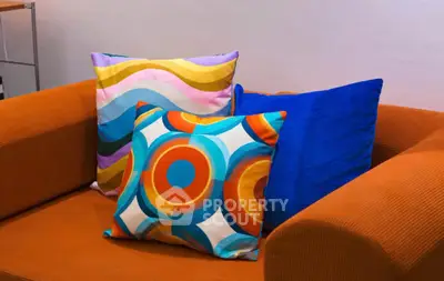 Stylish living room with vibrant cushions on an orange sofa, perfect for modern interiors.