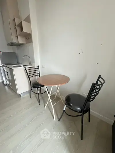 Cozy kitchen corner with compact dining set and modern cabinetry.
