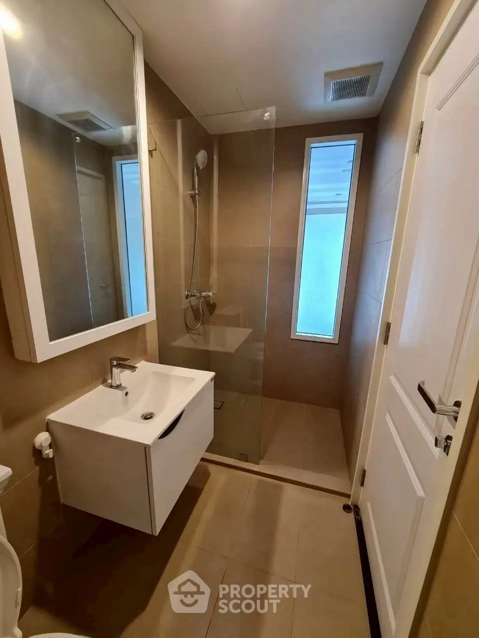 Modern bathroom with sleek shower and vanity in a compact space.