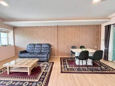 Spacious living room with modern decor and elegant wooden accents.