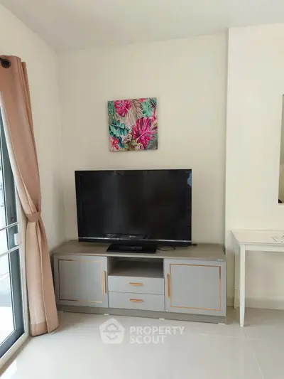 Modern living room with TV and stylish decor in a cozy apartment.