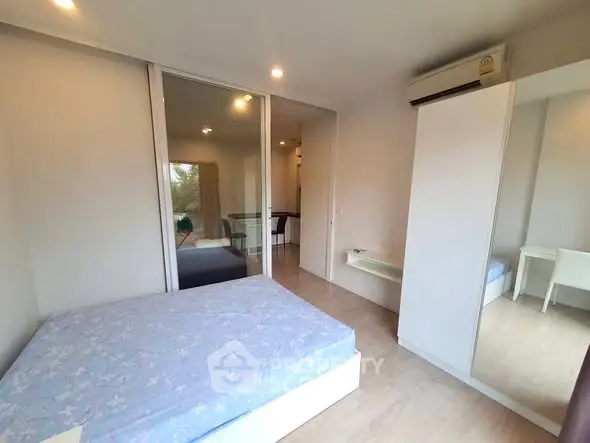 Modern bedroom with mirrored wardrobe and air conditioning in a stylish apartment.