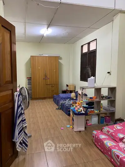 Spacious bedroom with wooden flooring and ample storage, perfect for a cozy family setup.
