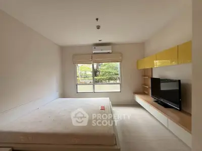 Spacious bedroom with modern furnishings and large window view