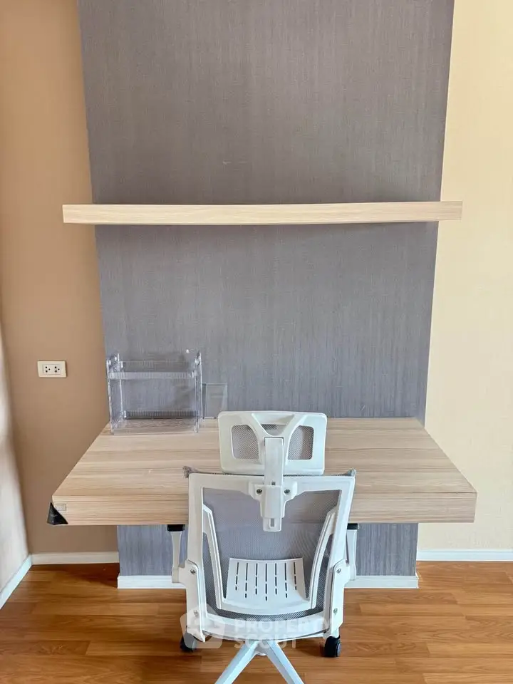 Modern study area with sleek desk, ergonomic chair, and wall shelf in a stylish home office.