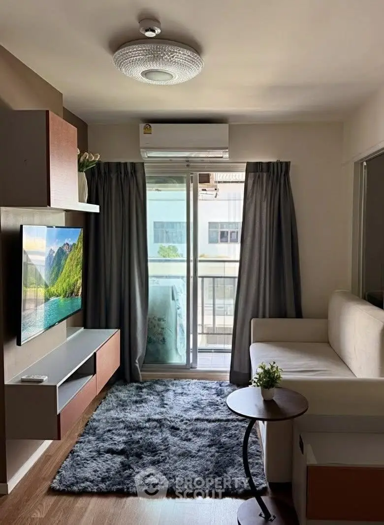 Modern living room with balcony access, featuring sleek furniture and natural light.