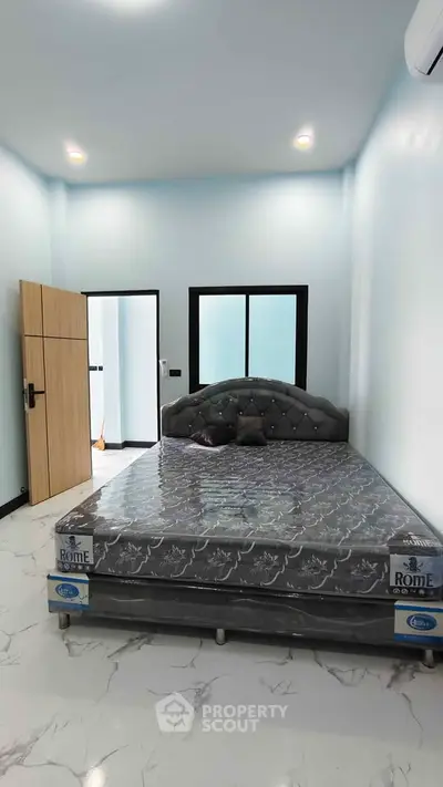 Modern bedroom with stylish bed and sleek wardrobe in a bright, airy space.