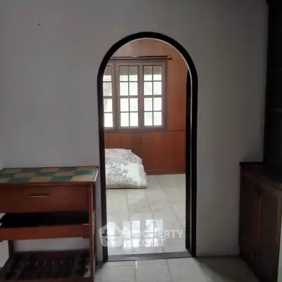 Charming interior with arched doorway leading to a cozy room with natural light.