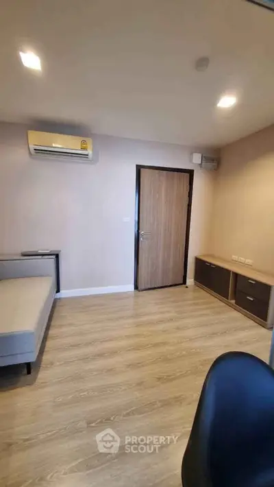 Modern living room with wooden flooring and air conditioning in a cozy apartment.