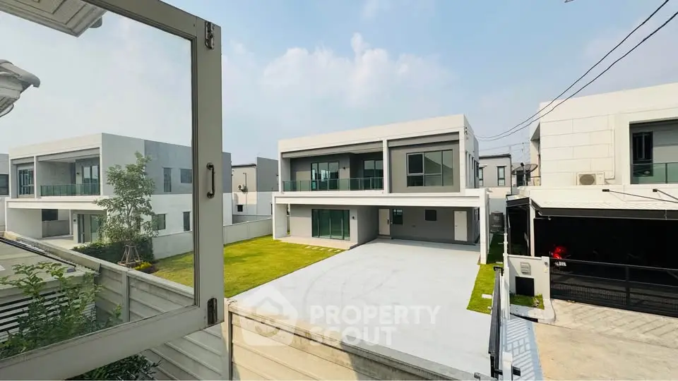 Modern luxury homes with spacious driveways and lush green lawns in a serene neighborhood.