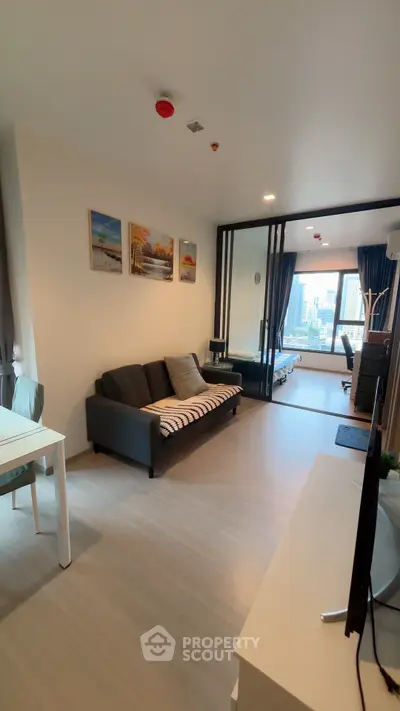 Modern living room with sleek design and city view, featuring a cozy sofa and stylish decor.
