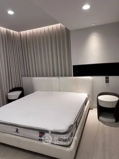 Modern bedroom with elegant lighting and stylish furniture, featuring a comfortable bed and sleek side tables.