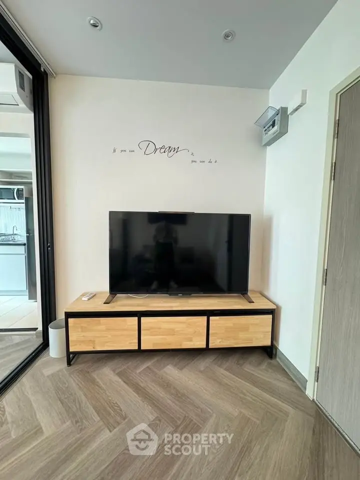 Modern living room with stylish TV stand and wall decor in a cozy apartment setting.