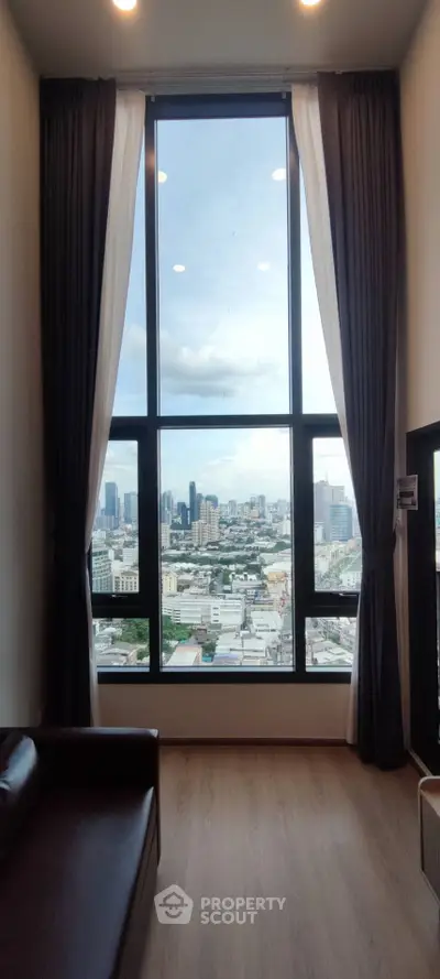Stunning high-rise apartment with floor-to-ceiling windows offering a breathtaking city view.
