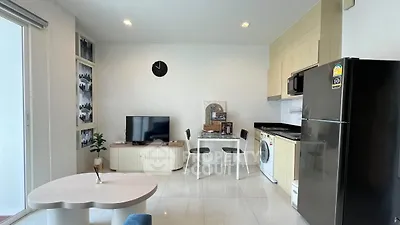 Modern living room with open kitchen, featuring sleek appliances and stylish decor.