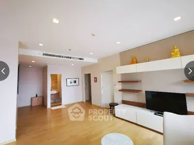 Spacious modern living room with wooden flooring and stylish shelving.