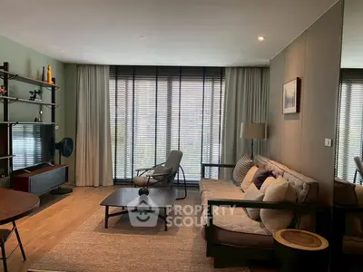 Stylish modern living room with cozy seating and large windows for natural light.