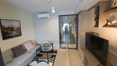 Modern living room with stylish decor and glass partition leading to kitchen area.