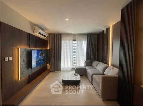 Luxurious modern living room with sleek design and large TV, perfect for relaxation and entertainment.