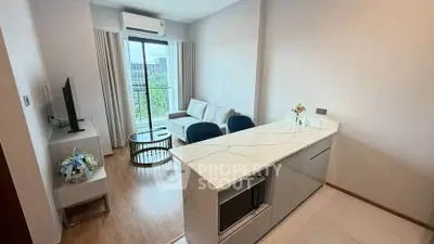Modern living room with open kitchen and stylish decor in a bright apartment.