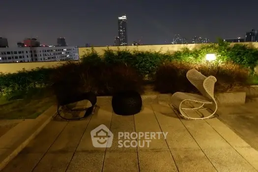 Stunning rooftop view with modern seating and city skyline at night.
