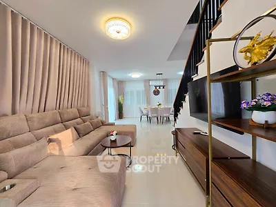 Spacious modern living room with elegant decor and open dining area, perfect for family gatherings.